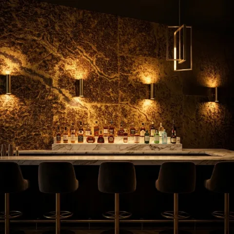 Luxury boutique hotel bar interior with antiqued gold foil wallcovering on the main feature wall