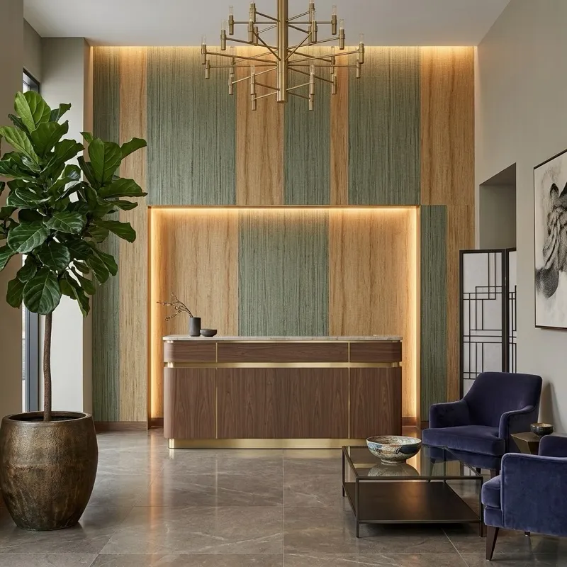 Luxury boutique hotel lobby with warm golden grasscloth wallcovering behind reception desk, velvet chairs and brass accents