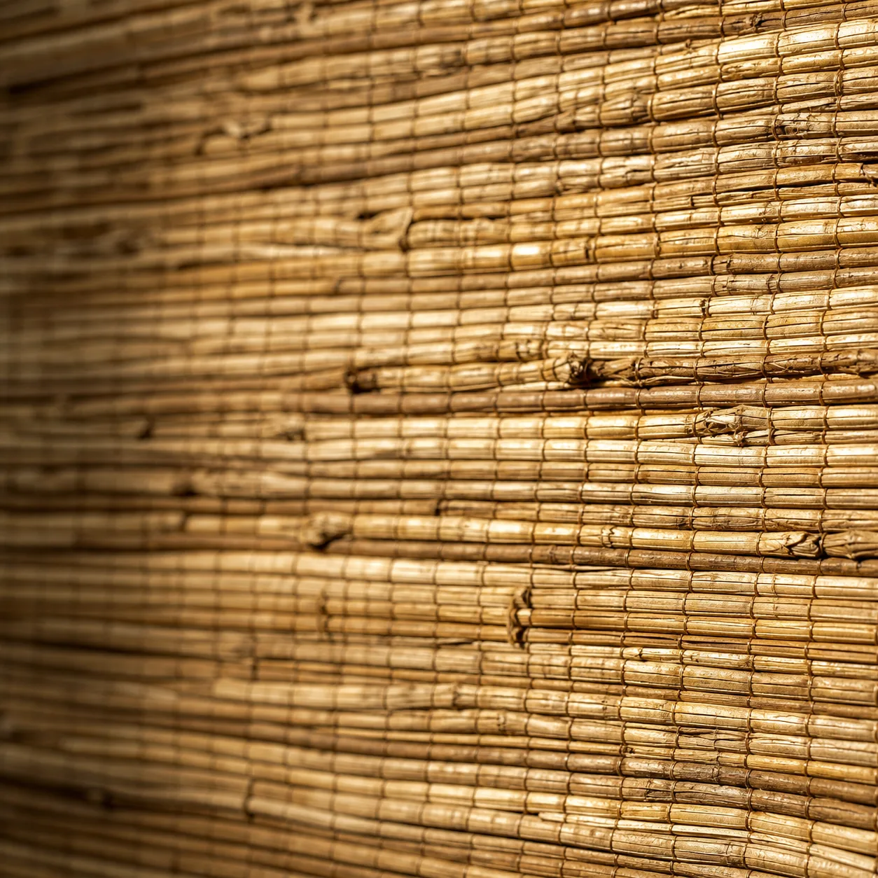 Extreme close-up comparison of real grasscloth natural fiber weave texture versus faux grasscloth smooth printed vinyl texture