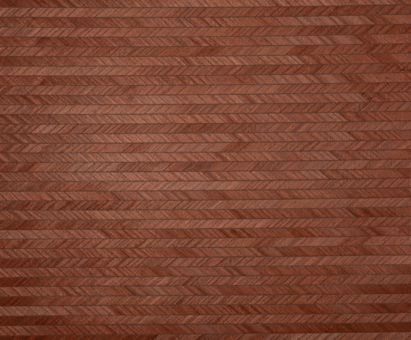 Крупный план образца Ember Chevron — травяные обои ёлочкой цвета терракота из мелкого равномерно окрашенного натурального тростника, нити кирпично-красного цвета в плотном шевронном плетении
